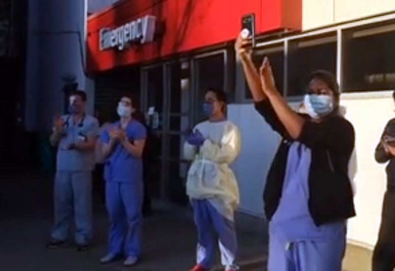 Front-line health-care workers at Burnaby Hospital respond to a salute from police, firefighters and paramedics Wednesday in a screen grab from a video posted on social media. Residents in Coquitlam are also being asked to participate in a nightly cheer during the 7 p.m. shift change at hospitals and health care facilities.