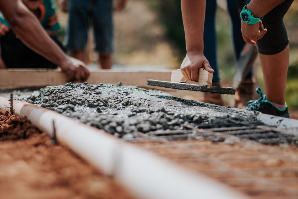 People building a walkway with cement-looking stuff