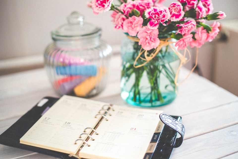 Day planner on a desk with flowers on it