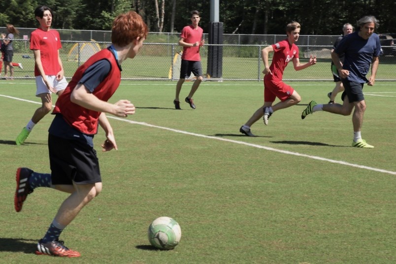 Youth playing soccer on turf field