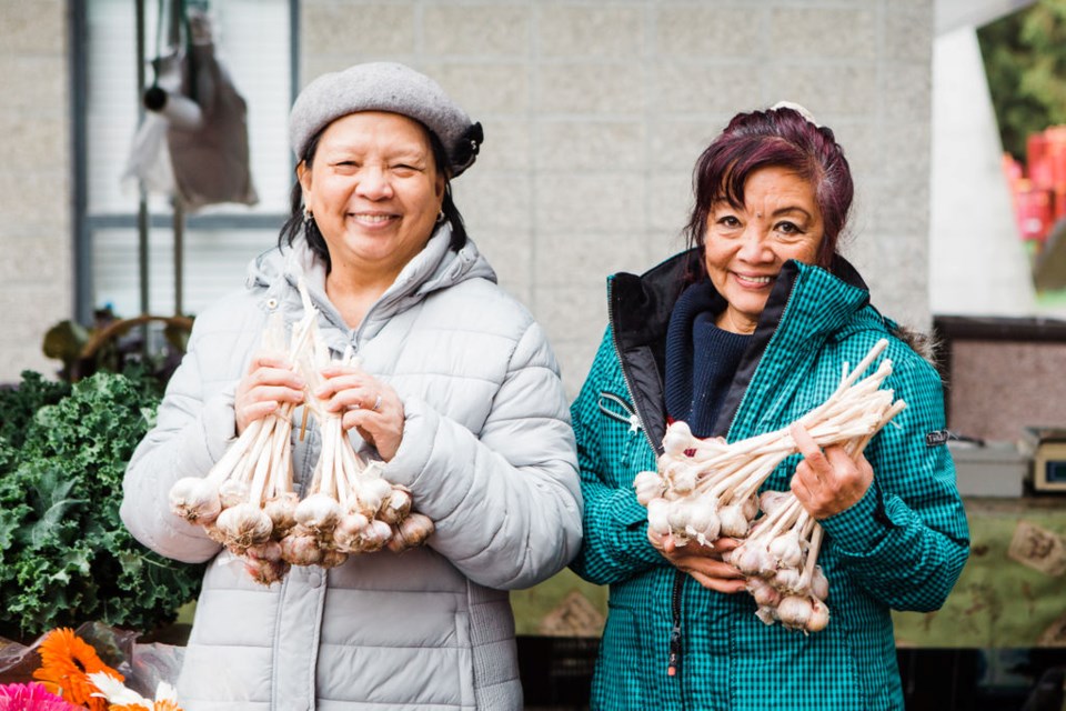 Shoppers pick up garlic at the Port Moody farmers market.