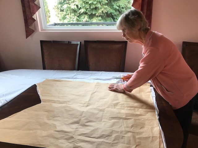 A volunteer cuts fabric for one of the gowns in the Dress the Docs