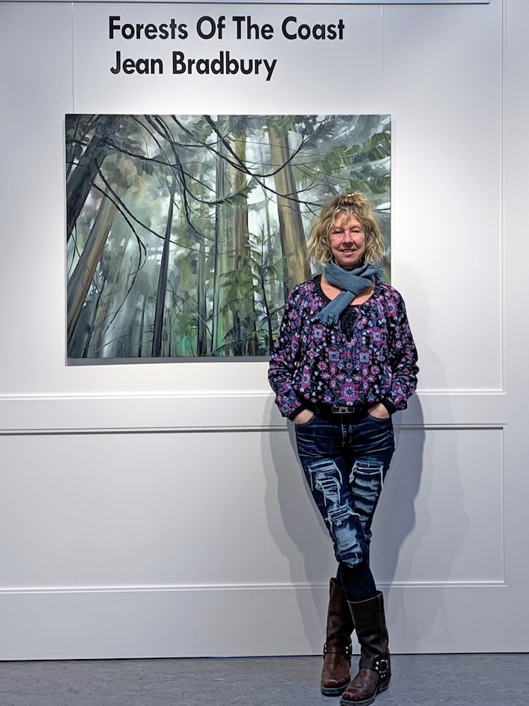 Jami Scheffer standing before a painting in the gallery