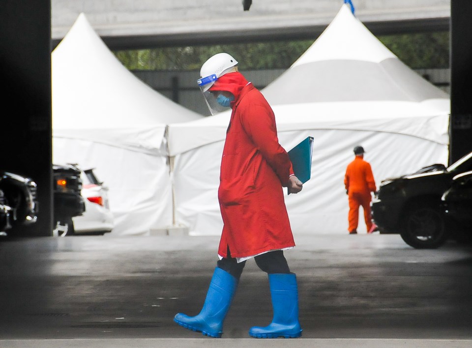 An employee at the Superior Poultry Processors Ltd. mans the gate Thursday with a infrared thermomet