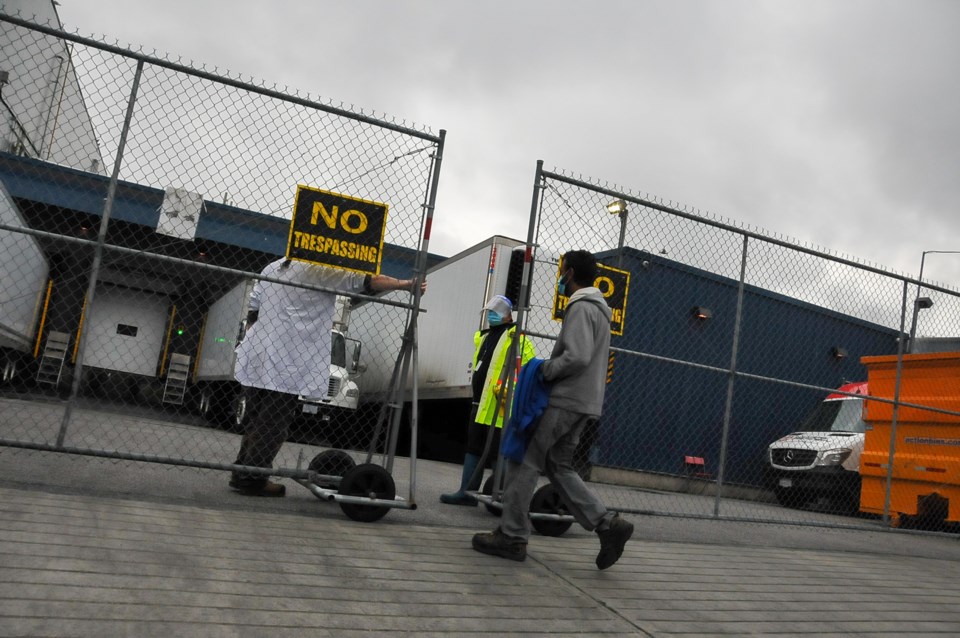 An employee enters a Coquitlam poultry factory on lockdown Thursday.