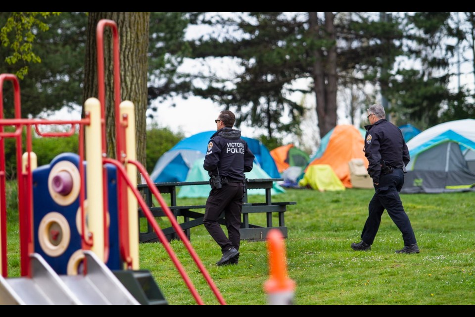 Police patrol the soon-to-be-dismanted homeless camp at Topaz Park. The residents will be moved to hotel rooms.