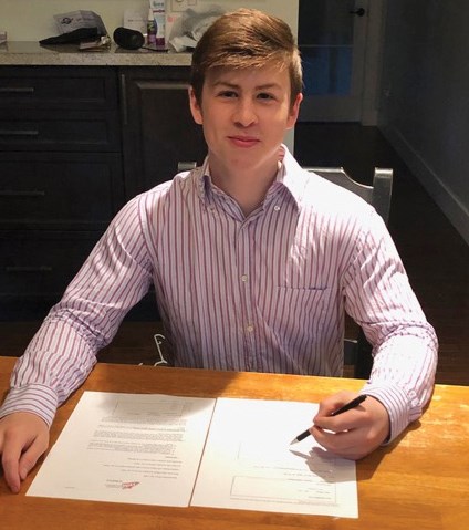 Oliver Tulk signing his player agreement.