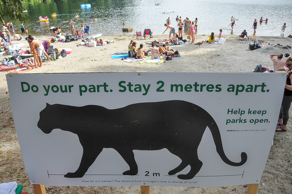 Metro Vancouver sign reminds beach-goers to maintain physical distance at Belcarra Regional Park's W