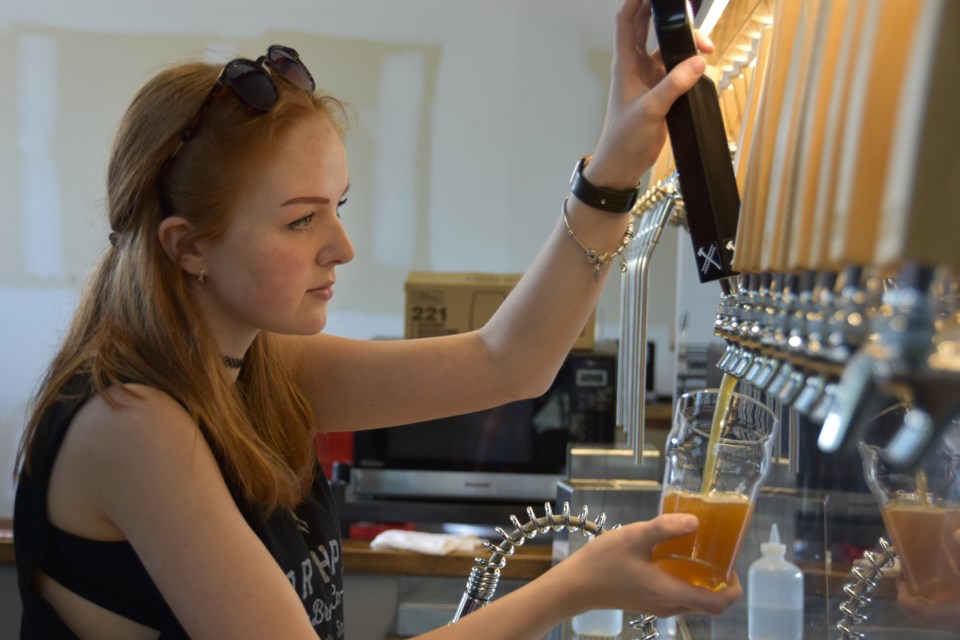 A server pours out a glass of Ring the Alarm Lager, when patrons were allowed to drink inside Northpaw Brew Co. The day will come soon when patrons will be allowed to do so again — but with strict social distancing protocols in place.