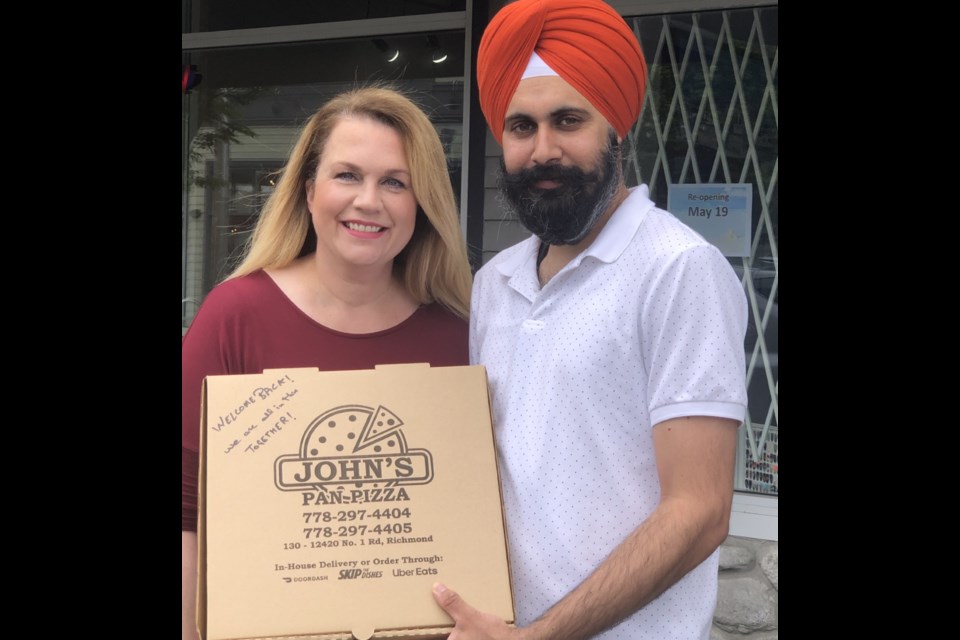 Nancy Bergeron and Pushpinder with the "Welcome Back" pizza box. Photo: Armando Diaz