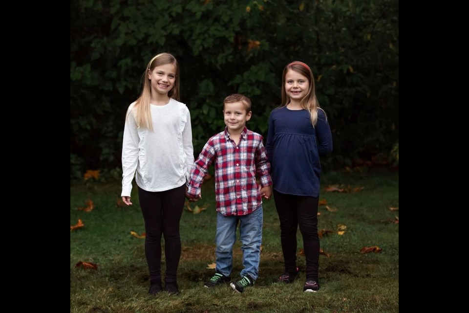 Ben Boon, middle, with his sisters Audrey, left, and Emily, right. The five-year-old Ben, who is currently battling leukemia, celebrated his fifth birthday on Thursday with a visit from Port Coquitlam Fire and Rescue, the Coquitlam RCMP and BC Sheriffs.