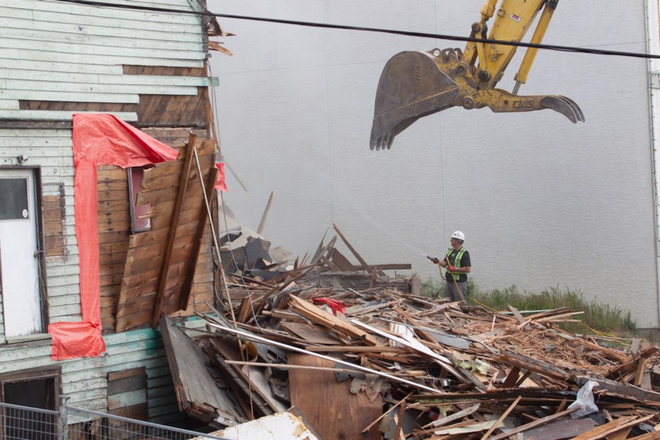 Workers demolish a building at Esquimalt Road and Head Street to make way for a 10-storey mixed-use project by Lexi Development. May 22, 2020