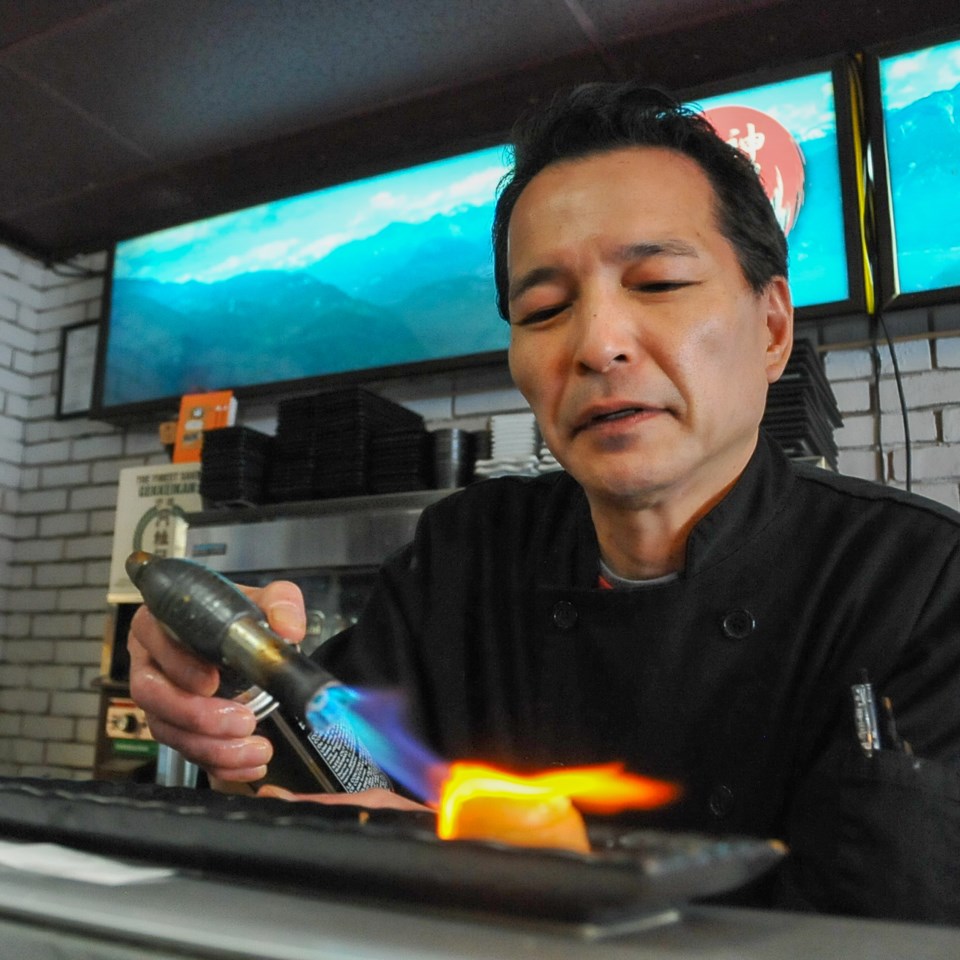 Keith Kamizato sears the butterfish with a blowtorch, a step that gives the sushi piece a light smok