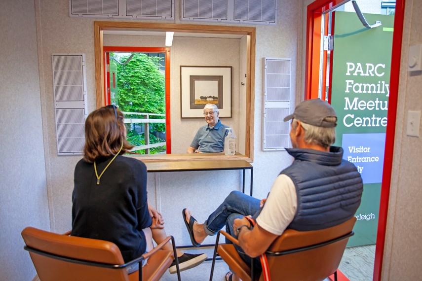 ack Hollands, a resident at Westerleigh PARC Retirement Living in West Vancouver, is visited by two family members in one of PARC's new meetup centres. The pod-like structures, built adjacent to the retirement home, are designed to allow for face-to-face visits while still maintaining a physical barrier in the era of COVID-19. photo PARC Retirement Living