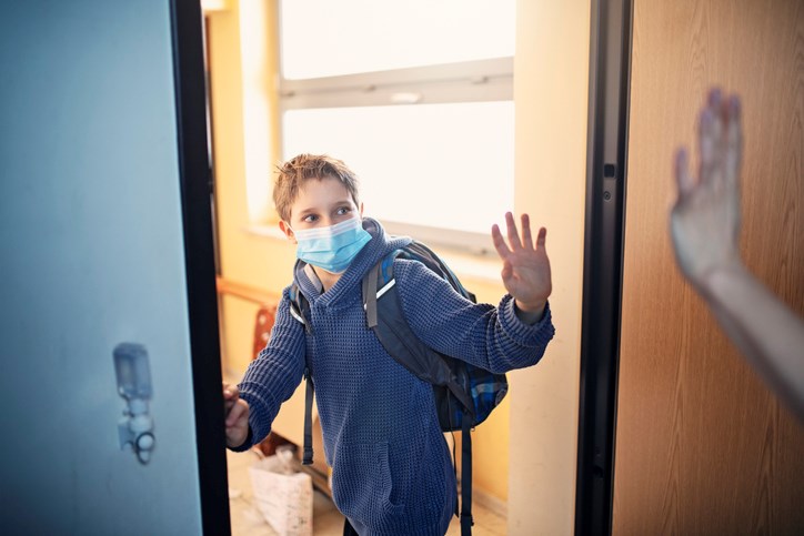A student heads to school wearing a mask.