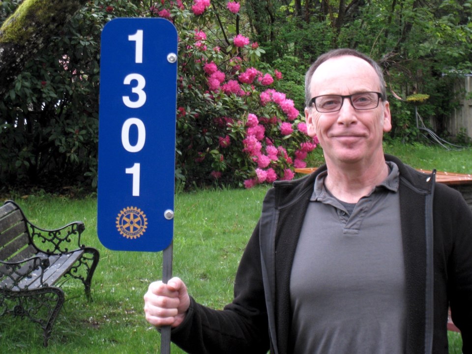 Ross holding a blue number plate sign