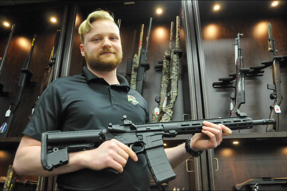 Assistant manager of Tiger Arms, Josh Faber, displays one of dozens of AR-15 variants his store has been sitting on with since they were banned with roughly 1,500 other guns May 1. Now he says RCMP are quietly adding more to that list.