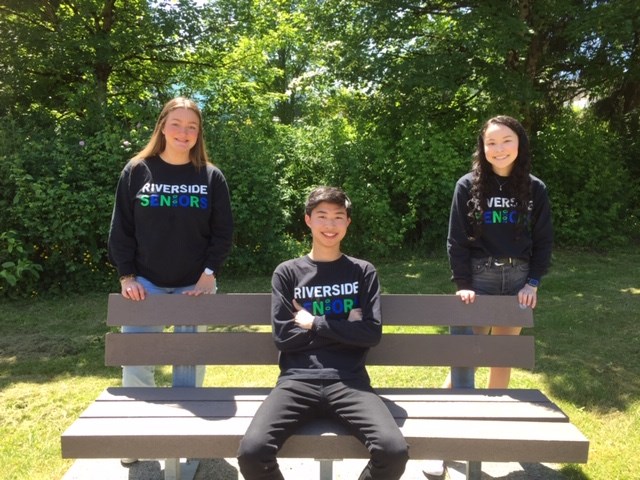 Riverside secondary grads Jayden Bawden, Jonathan Szto and Holly Coughlan show off the legacy bench at Settlers Park the Riverside class of 2020 has purchased with money they raised for local programs.