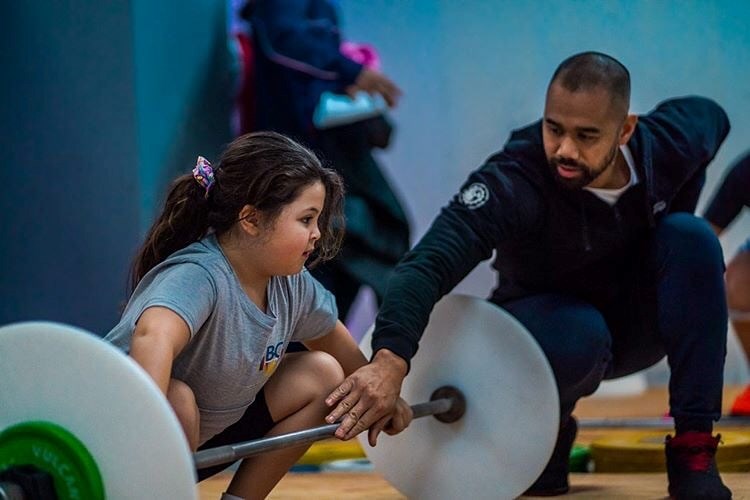 A coach helps a girl train at Engineered Bodies in Port Moody. It was the first gym in the Lower Mai