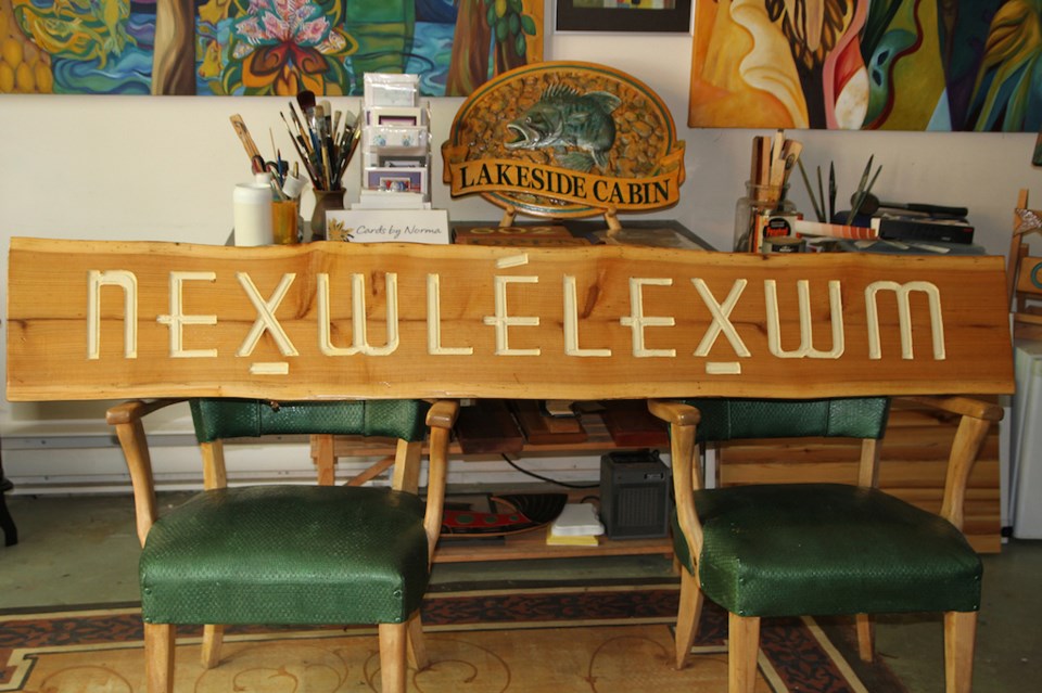 Wooden sign propped up on two chairs