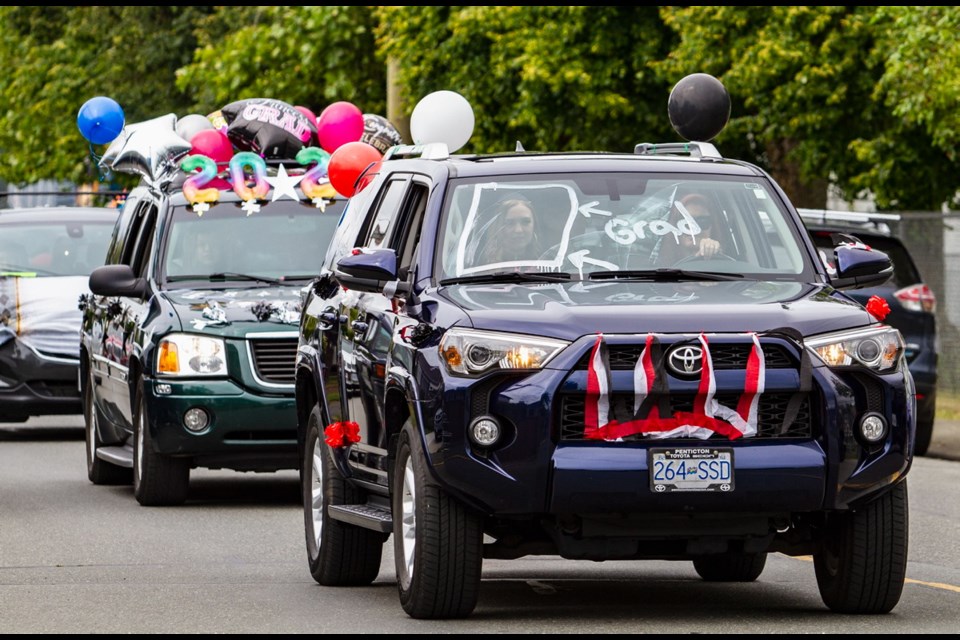 Esquimalt Secondary School grads roll out with balloons, bunting and imaginative windshield displays during a vehicle procession on Lyall Street.