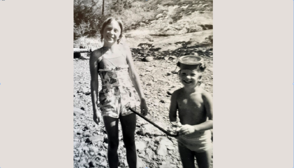 Two young girls on a rocky beach