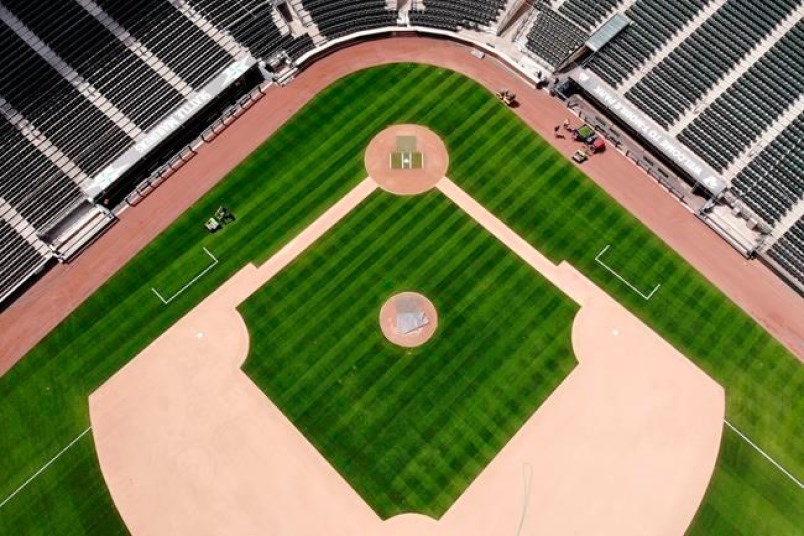 Grounds crew members work on the Seattle Mariners' field in May. Pro sports in North America are battling to get back on the field following a first half of 2020 dominated by coronavirus concerns. photo AP Photo/Elaine Thompson