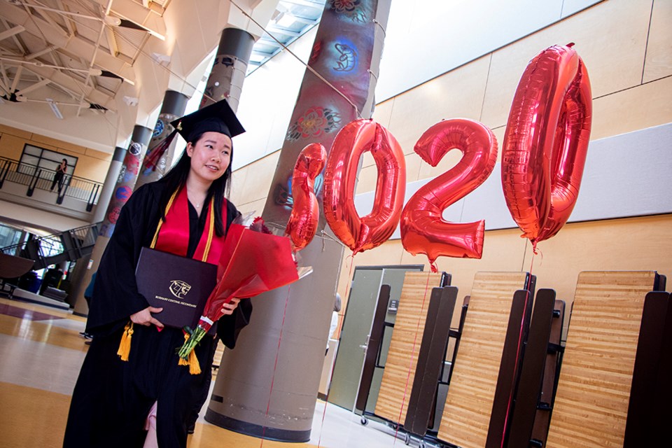 Ellie Li walks past a set of balloons that read “2020” after posing for photos on stage with Burnaby Central Secondary principal Dianne Carr during the school’s grad ceremony.