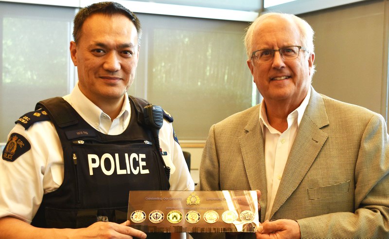 Supt. Will Ng (left) presenting the Richmond RCMP's cultural series to Richmond mayor Malcolm Brodie. Photo: Richmond RCMP