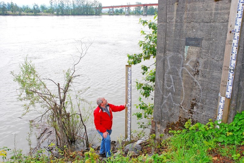 Steve Litke of the Fraser Basin Council measures Fraser River water levels at the Mission gauge. The dark plaque on the concrete marks the peak water height set in 1894. Water levels are expected to approach six metres here by Monday, July 6.