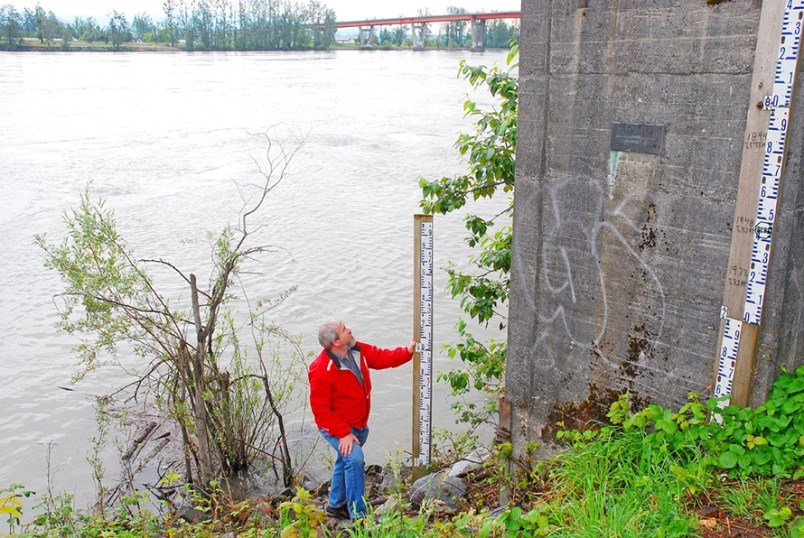 Steve Litke of the Fraser Basin Council measures Fraser River water levels at the Mission gauge. The dark plaque on the concrete marks the peak water height set in 1894. Water levels are expected to approach six metres here by Monday, July 6.
