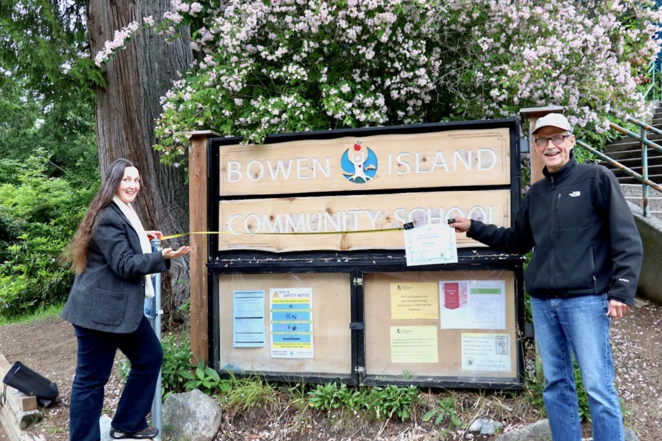 Local filmmaker Bob Turner (right) is one of the recipients of this year’s community spirit awards for sharing and spreading his endless enthusiasm for Bowen and Howe Sound’s natural world. He received his award from community school coordinator Sarah Haxby, from exactly six feet away from Turner.