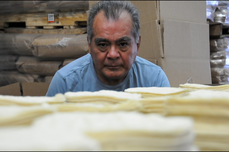 Carlos Hernandez checks on stacks of corn tortillas as they roll off the assembly line at his Santa Rosa factory in Port Coquitlam.