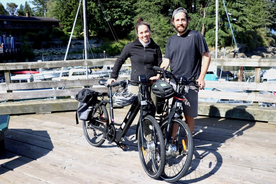 Two people standing beside bikes