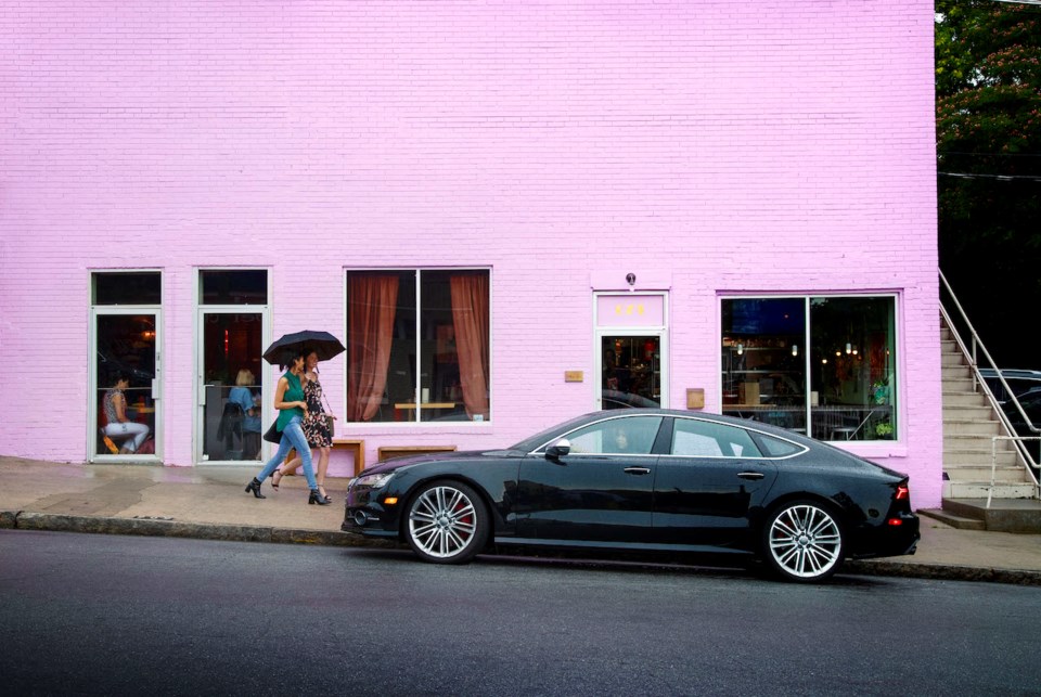 Car on the road with the backdrop of a purple building