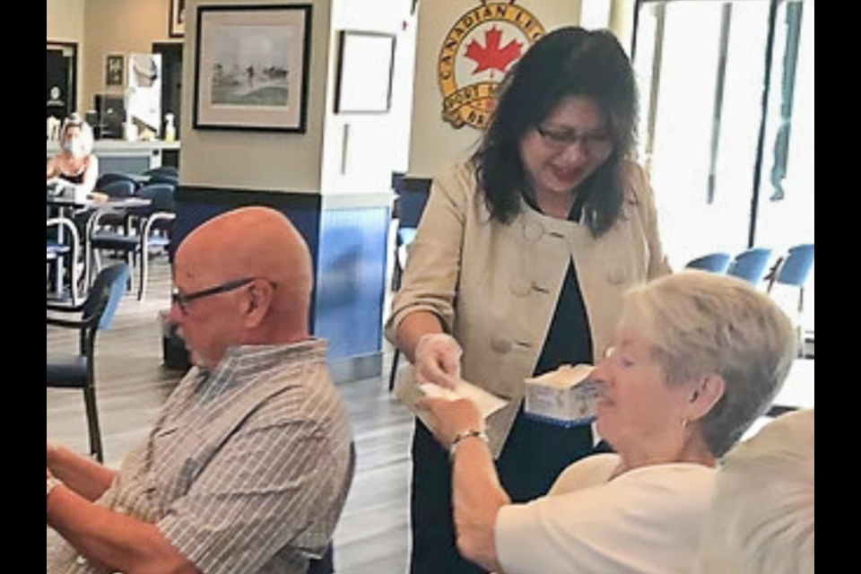 A mask-less Nelly Shin, Conservative MP for Port Moody-Coquitlam, hands out masks to seniors at the Port Moody branch of the Royal Canadian Legion.
