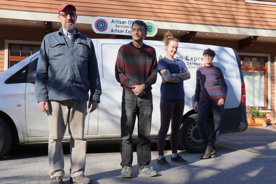 Artisan's delivery people standing in front of the delivery van parked before the office