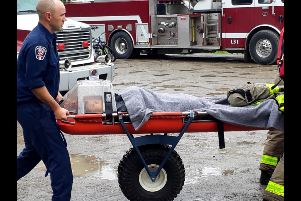 Prince George Fire Rescue firefighters used a big wheel stretcher to drag a woman to safety after she flipped off her mountain bike while riding the trails at Forest for the World Saturday morning.