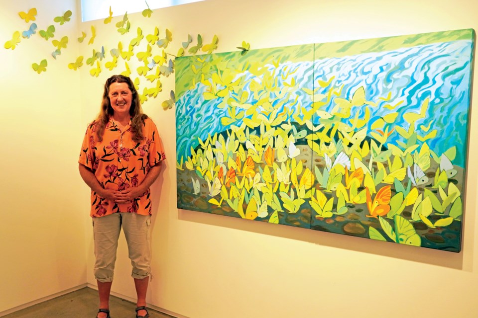 Greta Guzek with her mixed-media work, Lightness of Being.