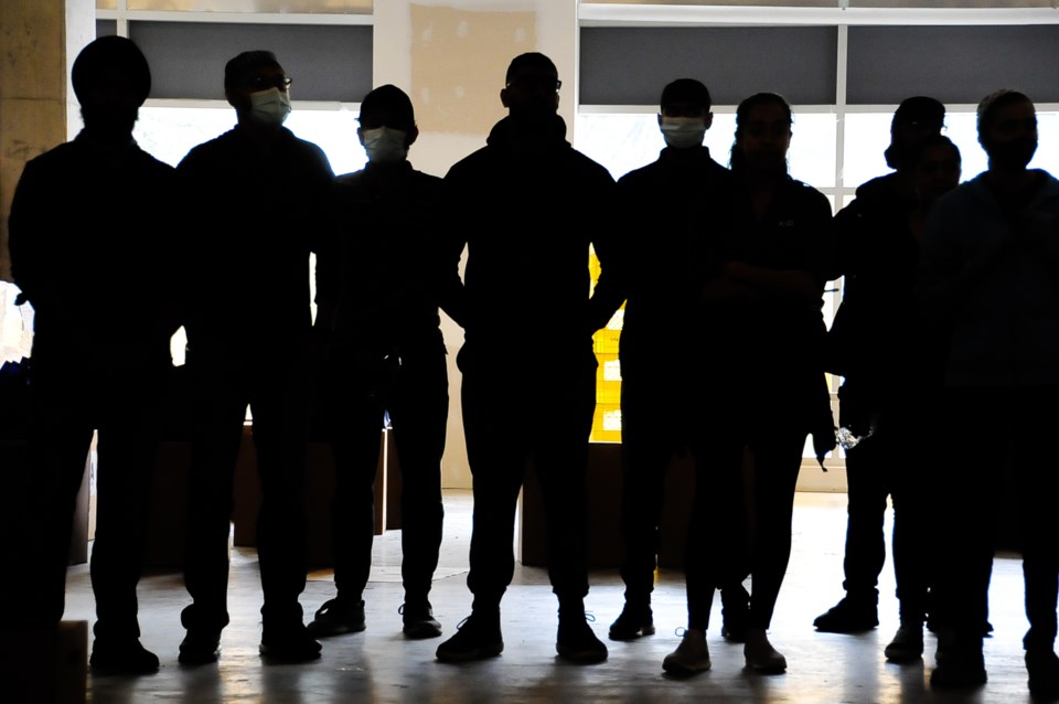 Volunteers gather during food distribution day, when boxes and bags of groceries are delivered to th