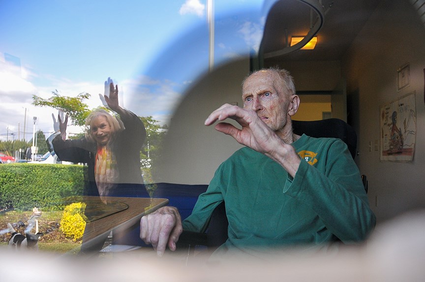 Brigitte Buermann waves to her husband Bernie, who suffers from vascular dementia and has spent four months under lockdown at a long-term care home in Port Coquitlam. Brigitte has window-visited every day since the pandemic began, and now that measures are slowly being lifted, she worries her 15 minutes a week won’t save him from forgetting her all together. “If I could gown up, I would – I’d go in there,” she said