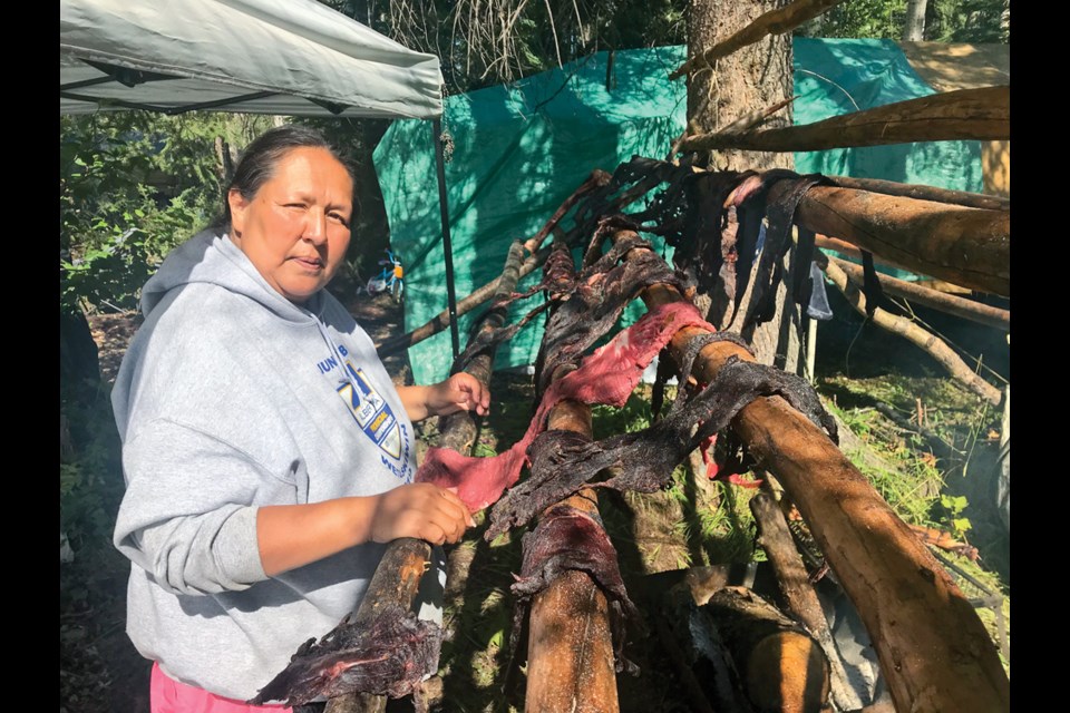 Tracy Paquette hangs moose meat to dry at a camp near the Blueberry River First Nation, July 18, 2020.