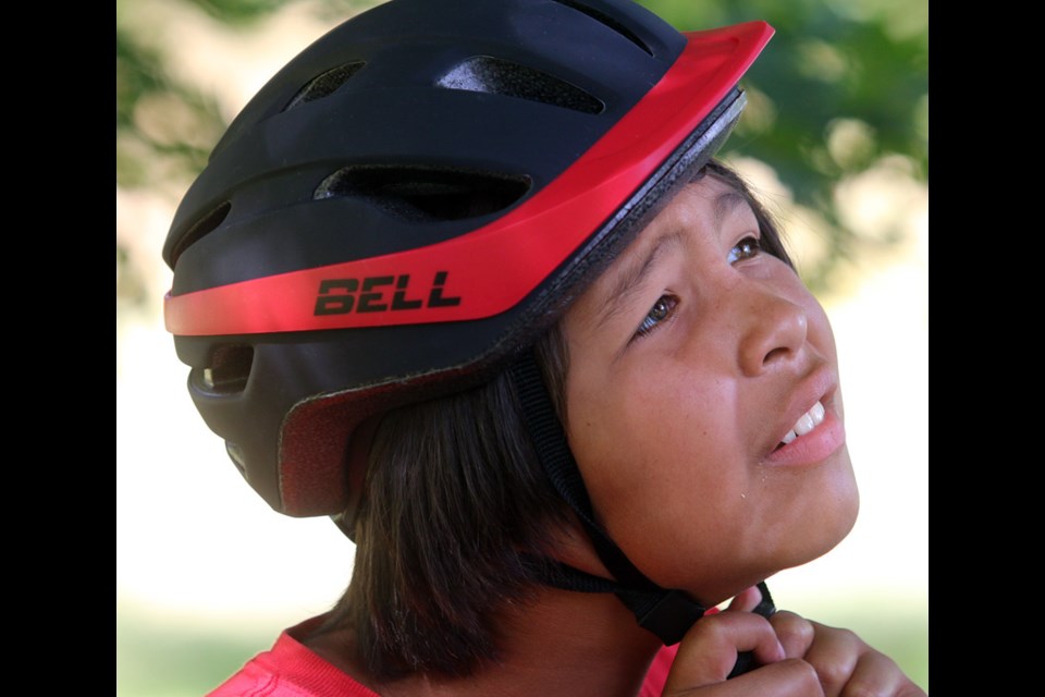 MARIO BARTEL/THE TRI-CITY NEWS
Antonio Joe, 11, tries on his new helmet at a special bike rodeo put on by Coquitlam RCMP at Kwikwtlem First Nation on Tuesday.