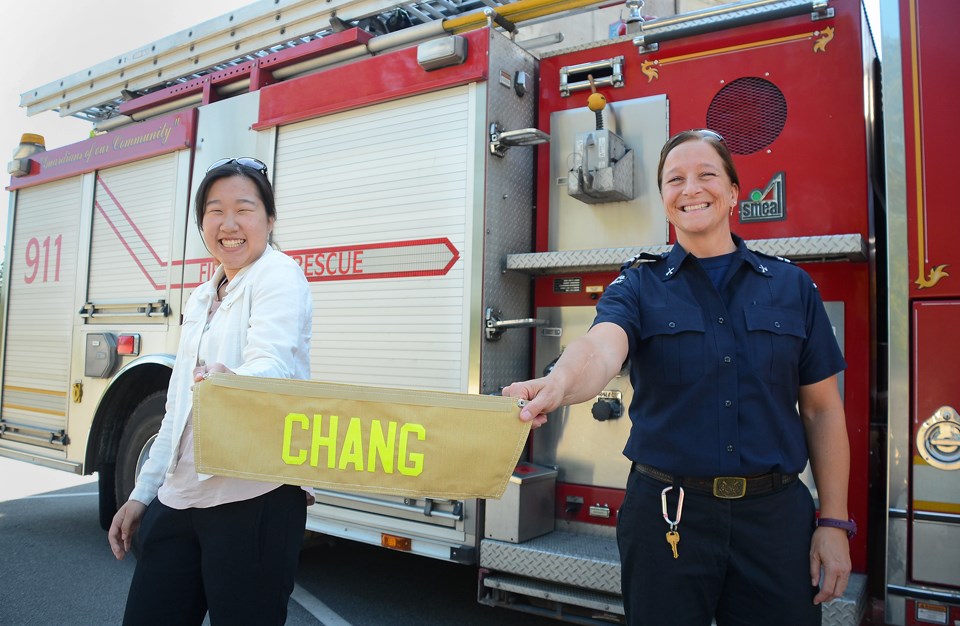 Byrne Creek Community School grad Irene Chang and Burnaby Fire Department Lt. Heather Wilson show off the personalized name bar Chang will wear on the back of her turnout gear at Camp Ignite, an all-girls firefighting camp this weekend.