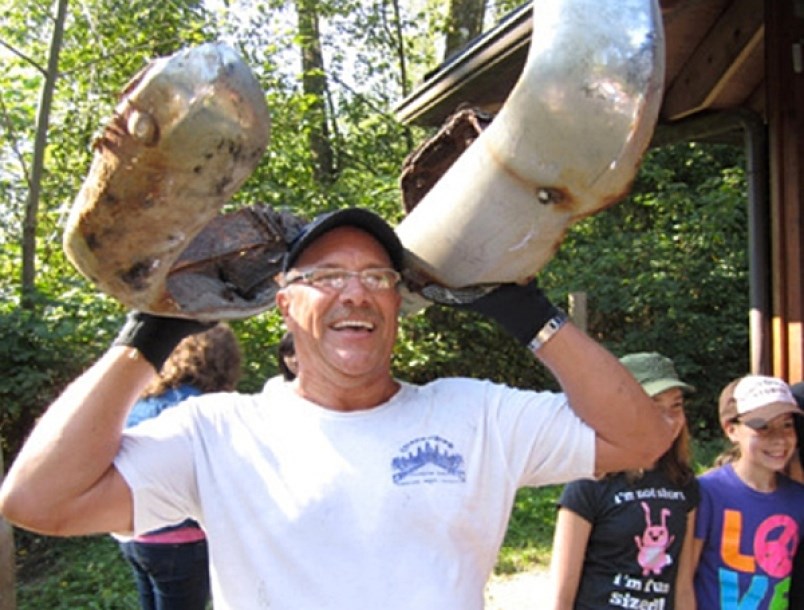 A Shoreline Cleanup volunteer shows off a car bumper he picked up during the annual event in Port Moody.