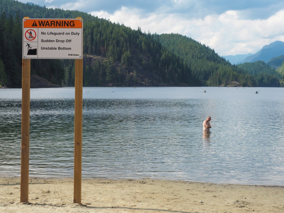 A man wades into the waters of Buntzen Lake. As BC Hydro's most popular recreation area in the provi