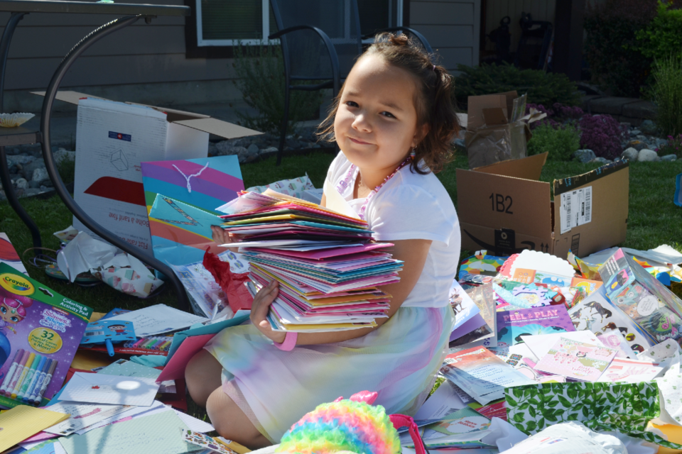 Six-year-old Charlie Manning with some of the hundreds of cards she received from birthday well-wishers from across the globe.