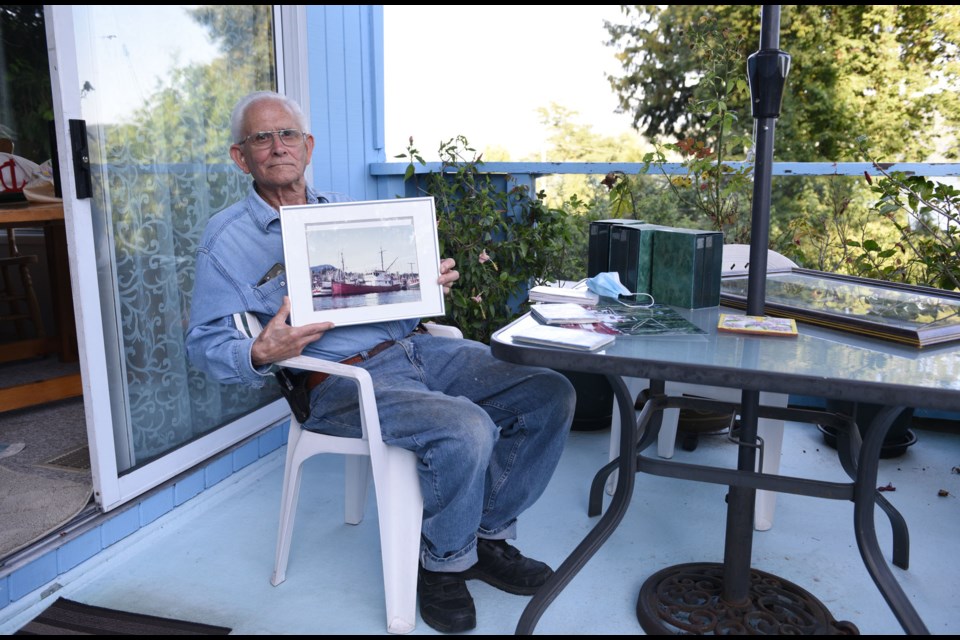 Ivan Tentchoff holds a photograph of the Arctic Fox II on his deck in Gibsons.