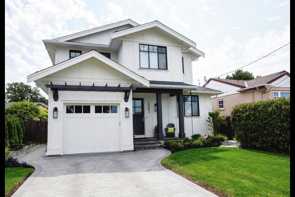 The exterior of the house has a country style garage and charming outdoor lighting. The front entrance to the home includes a Muskoka chair for relaxing and another place to enjoy the garden. DARREN STONE, TIMES COLONIST