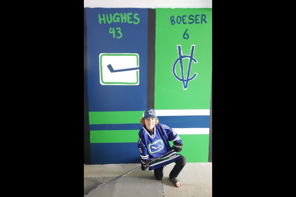 Ryder Starchuk, 8, with his hockey-themed mural in his garage. Photos submitted